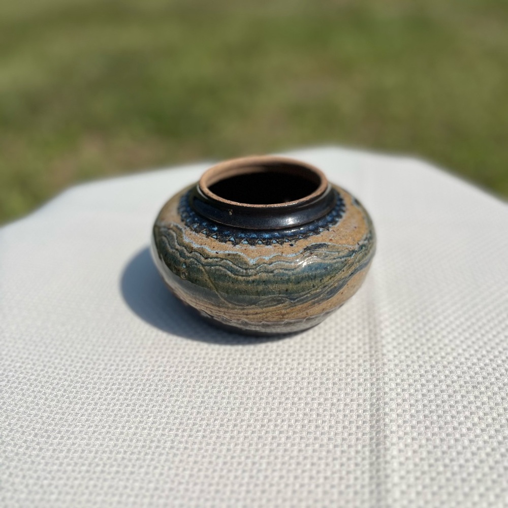 Handmade pottery bowl with artist signature on bottom.
